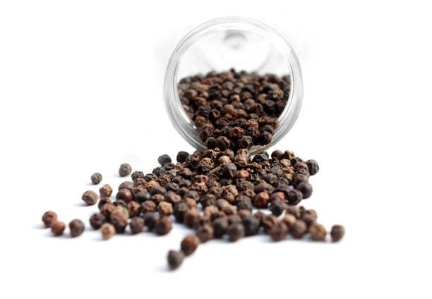 Black pepper background. Black pepper is a flowering vine in the family Piperaceae, cultivated for its fruit, known as a peppercorn, which is usually dried and used as a spice and seasoning. When fresh and fully mature, the fruit is about 5 mm in diameter, dark red, and contains a single seed, like all drupes.